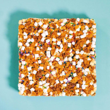 Square Cereal Milk Rocky Road topped with crunchy cornflakes, malted marshmallows, and colorful sprinkles from Crumbs & Doilies